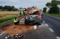 rozbity fiat i policjant wykonujący oględziny pojazdu