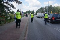 mundurowi idą w kierunku rowerzystów, którzy czekają na otwarcie zapór