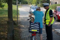 policjant rozmawia z rowerzystą, sprawcą wykroczenia