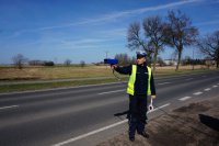 policjant mierzy prędkość z jaką porusza się nadjeżdżający pojazd