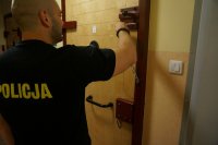policjant zamyka zatrzymanego w celi