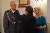 Burmistrz wręcza medal asp. Adamowi Kozakowi
