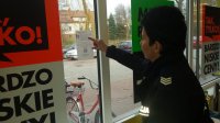Policjantka przywiesza ulotkę dot. kradzieży