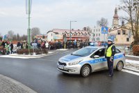 Policjant z drogówki wstrzymuje ruch na drodze przemarszu