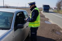Policjant sprawdza, czy kierowca ma pasy