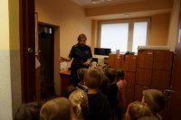 Policjantka pokazuje biura, w których pracują policjanci