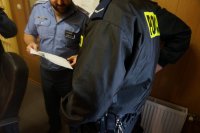 Policjanci i funkcjonariusze służby więziennej ogladają wizerunek uciekinierki