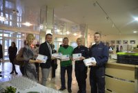 Wiceburmistrz z radnymi i policjantami wręczaja koperty
