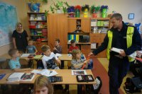 Policjant z drogówki wręcza odblaski