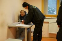 Zatrzymany podpisuje protokół zatrzymania