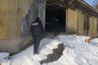 Policjanci wchodzą do opuszczonego budynku