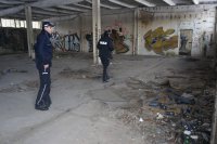 Mundurowi sprawdzają pomieszczenia pustostanu