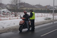 Policjant sprawdza stan trzeźwości kierującego skuterem