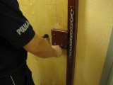 Policjant osada włamywacza w pomieszczeniu dla osób zatrzymanych