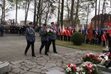 Policjanci składają wiązankę pod pomnikiem