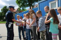 Policjanci wręczają odblaski uczestnikom egzaminu