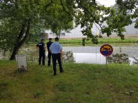 Policjanci i strażnik miejski kontrolują zbiorniki