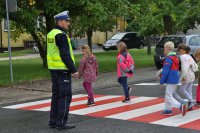 Dzieci pod okiem policjanta przechodzą przez przejście