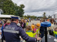Policjanci z drogówki pokazują najmłodszym motocykl