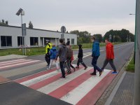 Policjant przeprowadza dzieci przez przejście
