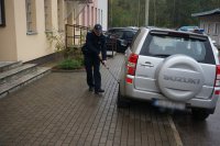 Policjanci wyciągają paczkę spod samochodu