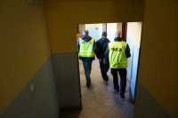Policjanci doprowadzają zatrzymanego
