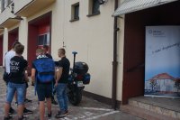 Młodzi ludzie oglądają policyjny motocykl i radiowóz