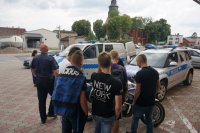 Policjanci prezentują motocykl i radiowóz