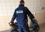 Na zdjęciu policjant stoi przy motorowerze.