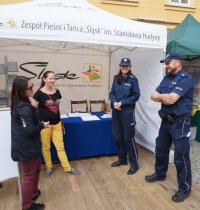 Na zdjęciu policjanci z KPP Lubliniec w czasie imprezy Dni Seniora w Koszęcinie stojący na tle namiotu wystawowego.