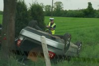 Na zdjęciu policjant drogówki w trakcie sporządzania dokumentacji z kolizji.