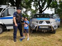 Na zdjęciu dziecko trzyma strzelbę gładkolufową w czasie pikniku &quot;Służby Mundurowe Dzieciom Gminy Koszęcin&quot;.