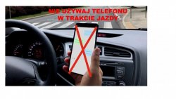 Na zdjęciu kierowca trzymający w ręce telefon komórkowy