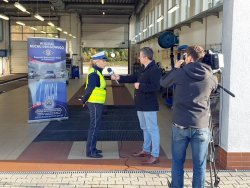 Na zdjęciu policjantka udziela wywiadu reporterowi na tle stacji diagnostycznej.