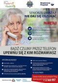 Na zdjęciu kobieta w podeszłym wieku trzyma w ręce słuchawkę telefoniczną oraz tekst ostrzeżenia przed oszustami na tzw. wnuczka.