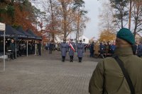 Na zdjęciu policjanci ze sztandarem stoją przed pomnikiem.