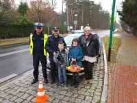 Na zdjęciu osoby biorące udział w akcji &quot;jabłuszko czy cytrynka na wspólnym zdjęciu na tle policyjnego radiowozu.