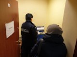 Na zdjęciu policjantka w mundurze przeprowadza badanie alkomatem .