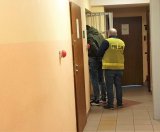 Na zdjęciu zatrzymany mężczyzna w czasie zakładania mu kajdanek przez policjanta.
