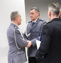 Na zdjęciu  uczestnicy pożegnania zastępcy komendanta powiatowego w Lublińcu. Składanie życzeń na koniec ceremonii przez umundurowanych policjantów.