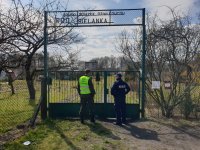 Na zdjęciu policjant i żołniez kontroilujący ogródki działkowe w Lublińcu.