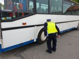 Na zdjęciu policjant w czasie kontroli autokarów.