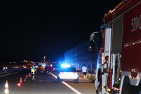 Na zdjęciu miejsce wypadku na autostradzie A1 , widoczny policyjny radiowóz na sygnale, policjant w trakcie czynności i wóz strażacki.