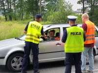 Na zdjęciu policjant i funkcjonariusze SOK wręczają ulotki dotyczące bezpiecznego przejazdu.