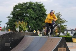 Na zdjęciu osoba na rowerze w trakcie jazdy na skateparku.