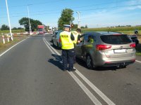 Na zdjęciu policjant rozmawiający z kierowcą oczekującym na otworzenie przejazdu kolejowego w Lisowicach.