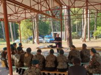 Na zdjęciu policjantka w mundurze prowadzi prelekcja dla młodzieży w Kokotku.