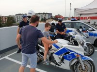 Na zdjęciu młody chłopiec siedzący na policyjnym motocyklu.