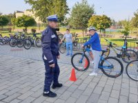 Na zdjęciu widoczny policjant w mundurze w czasie egzaminu na kartę rowerową w Szkole Podstawowej nr 2 w Lublińcu