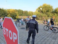 Na zdjęciu widoczny policjant w mundurze i dzieci na rowerach w czasie egzaminu na kartę rowerową.